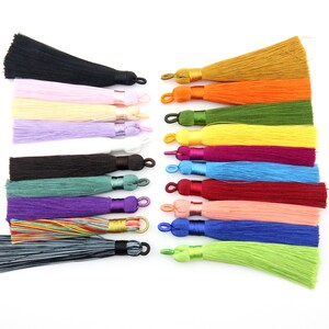 May include: Assortment of 18 colorful tassel trims with gold, orange, green, yellow, purple, blue, red, pink, and black colors. The tassels are made of soft, silky fabric and have a loop at the top for easy attachment.