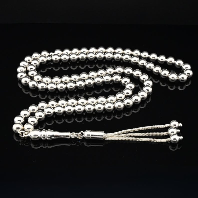 May include: A silver prayer beads necklace with a silver tassel. The beads are round and smooth.