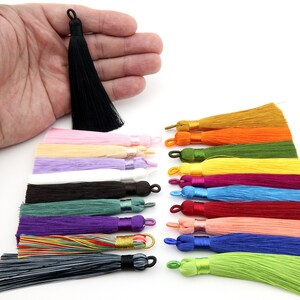 May include: Assortment of 18 colorful silk tassels in various colors, including black, white, pink, purple, green, yellow, orange, red, and blue. The tassels are approximately 2 inches long and are perfect for adding a touch of elegance to any project.