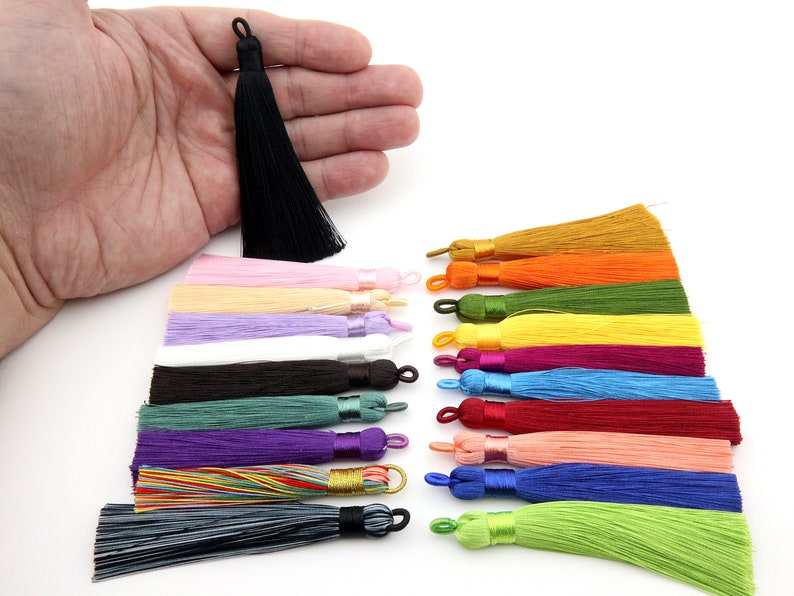 May include: Assortment of 18 colorful silk tassels in various colors, including black, white, pink, purple, green, yellow, orange, red, and blue. The tassels are approximately 2 inches long and are perfect for adding a touch of elegance to any project.