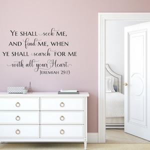Puede incluir: Una c&oacute;moda blanca con tres cajones y pomos dorados contra una pared rosa claro. Una calcoman&iacute;a de pared en blanco y negro con el texto "YE SHALL seek ME, AND find ME, WHEN YE SHALL search FOR ME with all your Heart. JEREMIAH 29:13" est&aacute; en la pared sobre la c&oacute;moda.