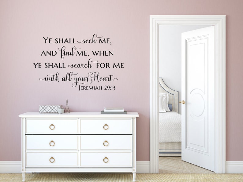 Puede incluir: Una c&oacute;moda blanca con tres cajones y pomos dorados contra una pared rosa claro. Una calcoman&iacute;a de pared en blanco y negro con el texto "YE SHALL seek ME, AND find ME, WHEN YE SHALL search FOR ME with all your Heart. JEREMIAH 29:13" est&aacute; en la pared sobre la c&oacute;moda.