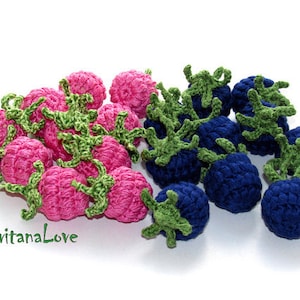 K&ouml;nnte beinhalten: Eine Sammlung geh&auml;kelter Himbeeren und Blaubeeren. Die Himbeeren sind rosa und die Blaubeeren sind blau. Beide sind mit gr&uuml;nen Bl&auml;ttern verziert.