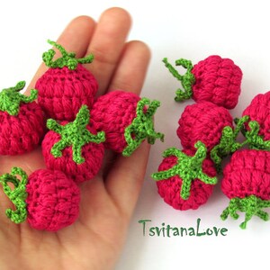 K&ouml;nnte beinhalten: Eine Sammlung von neun geh&auml;kelten Erdbeeren in Rosa- und Gr&uuml;nt&ouml;nen. Die Erdbeeren sind klein und haben ein realistisches Aussehen.