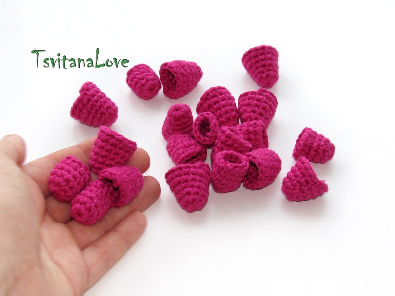 May include: A collection of 16 small, crocheted, pink flower buds.