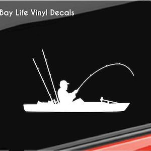May include: White vinyl decal of a person fishing from a kayak with two fishing rods. The decal says "Bay Life Vinyl Decals" at the top.
