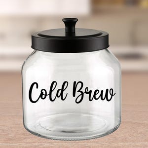 May include: A clear glass jar with a black lid and a black label that says "Cold Brew".