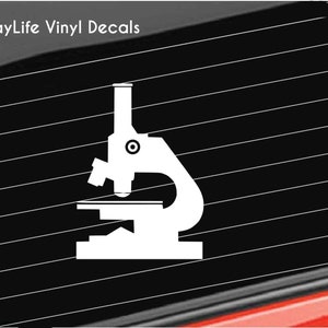 May include: White vinyl decal of a microscope. The decal is a silhouette of a microscope, with a base, stage, and ocular lens. The text "BayLife Vinyl Decals" is in the upper left corner.