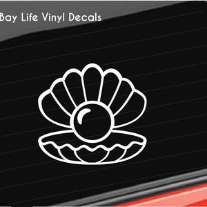 May include: A white vinyl decal featuring a line art illustration of an open clam shell with a pearl inside, displayed on a dark car window. The text Bay Life Vinyl Decals and a small bird icon are visible in the upper left corner of the image.
