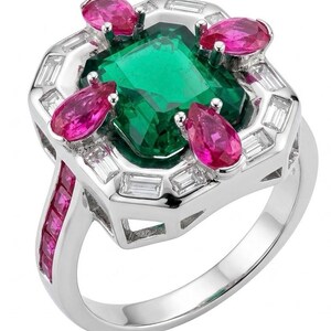 Peut inclure: Une bague en argent avec une grande pierre centrale verte de taille carrée entourée de quatre pierres roses en forme de poire. Le sertissage est orné de petites pierres blanches rectangulaires et d'une rangée de pierres roses carrées.