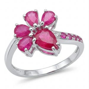 Puede incluir: Anillo de plata con diseño floral, con cinco gemas rojas vibrantes en forma de lágrima. La banda está adornada con piedras rojas más pequeñas. Una joya elegante para cualquier ocasión.