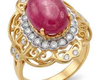 Könnte beinhalten: Ein Goldring mit einem großen, ovalen, im Cabochon-Schliff gehaltenen, tiefrosa Edelstein in der Mitte. Der Stein ist von einem gewellten Heiligenschein aus kleinen, runden, klaren weißen Steinen umgeben. Die Ringschiene und Fassung zeigen ein filigranes Goldmuster.