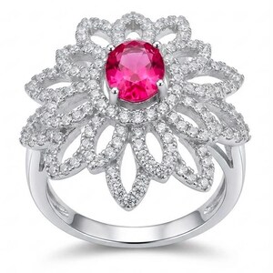 Puede incluir: Anillo plateado con una gema rosa brillante ovalada en el centro, rodeada por un diseño floral. El anillo está incrustado con pequeñas gemas claras, creando un efecto brillante. La banda es lisa y pulida.