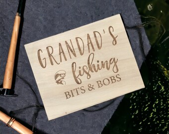 May include: A wooden sign with the text "Grandad's fishing bits & bobs" and a small image of a fish.