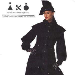 May include: A black long-sleeved coat with a high collar and a belt. The coat has a flared skirt and is decorated with small black dots. The model is wearing a black hat with a pointed crown and black boots.