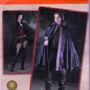 May include: A sewing pattern for a black and purple cape with a skull-shaped handle. The pattern number is 2529. The pattern is for sizes XS, S, and M. The pattern is from Simplicity.