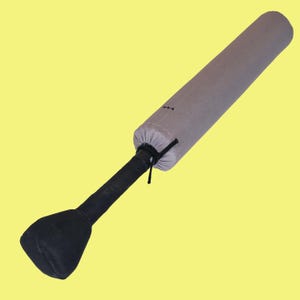 May include: A gray padded cricket bat cover with a black handle and a black padded end. The cover is cinched at the top with a black drawstring. The background is a solid yellow.