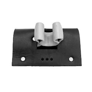 May include: Black leather holster with two white cylindrical holders and three asterisks. Two white rivets are on the sides. The holster is designed to hold an item.