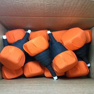 May include: A box filled with orange and black fabric pumpkins. The pumpkins are handmade and have a unique, rustic look.