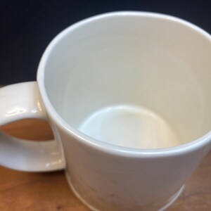 Puede incluir: Taza de cer&aacute;mica de color crema con asa redondeada. La taza tiene un acabado liso y brillante y un dise&ntilde;o sencillo y cl&aacute;sico. El interior tambi&eacute;n es de color crema. Adecuada para bebidas fr&iacute;as o calientes.