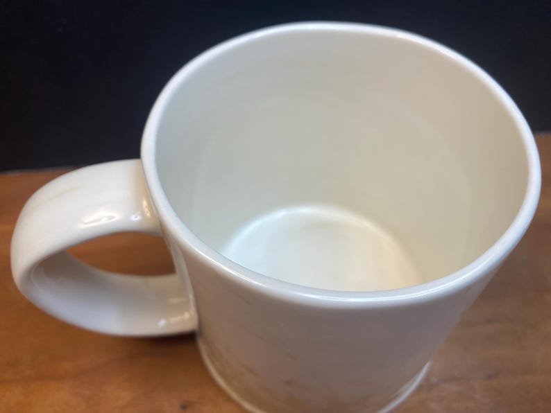 Puede incluir: Taza de cer&aacute;mica de color crema con asa redondeada. La taza tiene un acabado liso y brillante y un dise&ntilde;o sencillo y cl&aacute;sico. El interior tambi&eacute;n es de color crema. Adecuada para bebidas fr&iacute;as o calientes.