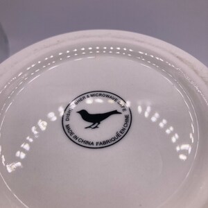 May include: White ceramic plate with a black bird logo that reads "Dishwasher & Microwave Safe Made in China Fabriqu&eacute; en Chine"