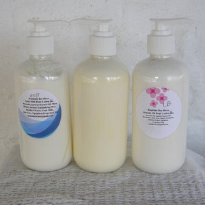 May include: Three white pump bottles of body lotion with labels. The labels are white with pink and blue accents. The labels include the text "Randalia Bee Hives" and the ingredients for each lotion.