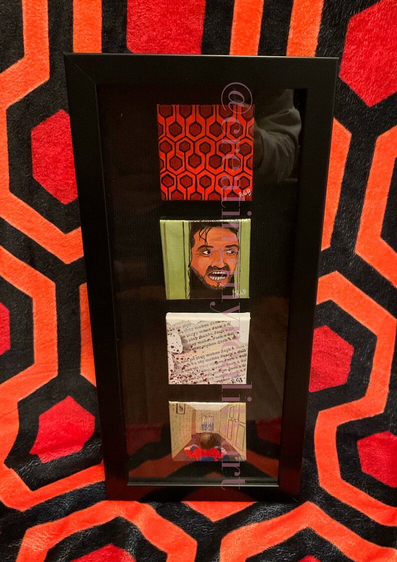 Puede incluir: Un conjunto enmarcado de cuatro peque&ntilde;as pinturas que representan escenas de la pel&iacute;cula "El Resplandor". Las pinturas incluyen el ic&oacute;nico patr&oacute;n de la alfombra roja, un primer plano del personaje de Jack Nicholson, una p&aacute;gina de un libro con salpicaduras de sangre y una escena de pasillo con un ni&ntilde;o peque&ntilde;o con un su&eacute;ter rojo.