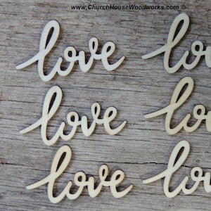 May include: Several wooden cutouts of the word "love" in a cursive script. The cutouts are made of light-colored wood and are arranged on a wooden surface. The website address "www.ChurchHouseWoodworks.com" is visible in the top right corner.