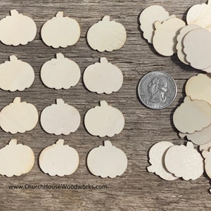 May include: A collection of unfinished wooden pumpkin shapes, perfect for crafting and decorating. The pumpkins are various sizes and are shown next to a US quarter for scale.