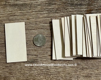 May include: A stack of 20 unfinished wooden rectangles, each measuring approximately 2 inches by 1/2 inch. The wood is a light beige color and has a smooth surface. A US quarter is included for scale.