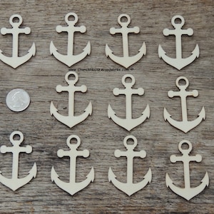 May include: Twelve unfinished wooden anchor shapes, each with a hole at the top for hanging. The anchors are approximately 2 inches tall and are arranged in four rows of three on a wooden surface.