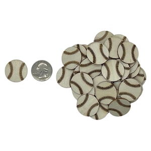 May include: A pile of wooden baseball-shaped ornaments with brown stitching details. The ornaments are approximately the size of a US quarter.