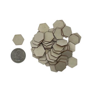 May include: A pile of unfinished, natural wood hexagon shapes. The hexagons are approximately the size of a US quarter.
