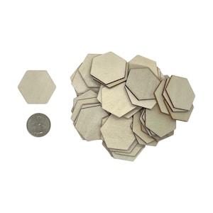 May include: A pile of unfinished wooden hexagon shapes, with one hexagon shape in the foreground for size comparison. The hexagon shapes are approximately the size of a US quarter.