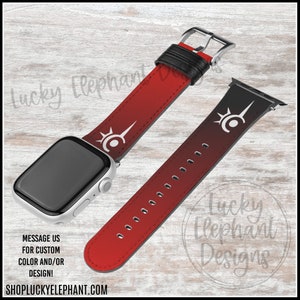 May include: Red and black Apple Watch band with a white design. The band has a gradient effect, fading from red to black. The design features a stylized symbol with a circle and a pointed shape.