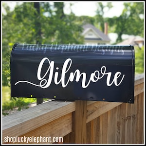 May include: A black mailbox with a white vinyl decal that says "Gilmore".
