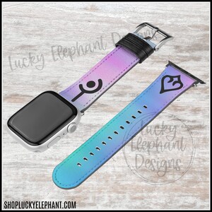 May include: A silver Apple Watch with a colorful watch band. The band features a gradient of purple, pink, and blue with black symbols. The watch band is made of leather and has a black buckle. The website address is visible at the bottom.