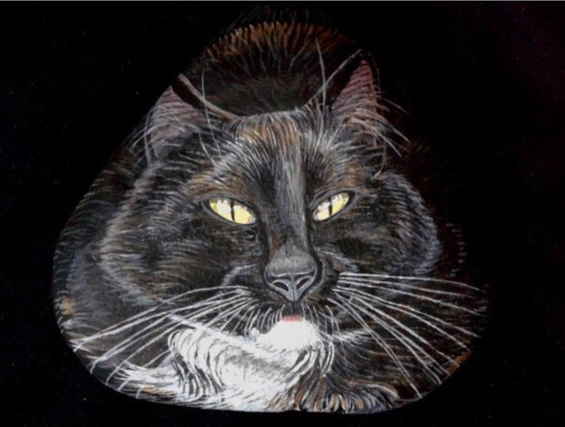 Puede incluir: Retrato pintado de un gato blanco y negro con ojos amarillos. El pelaje del gato est&aacute; detallado con tonos de negro, marr&oacute;n y blanco. El fondo es negro liso, resaltando la cara y los bigotes del gato.