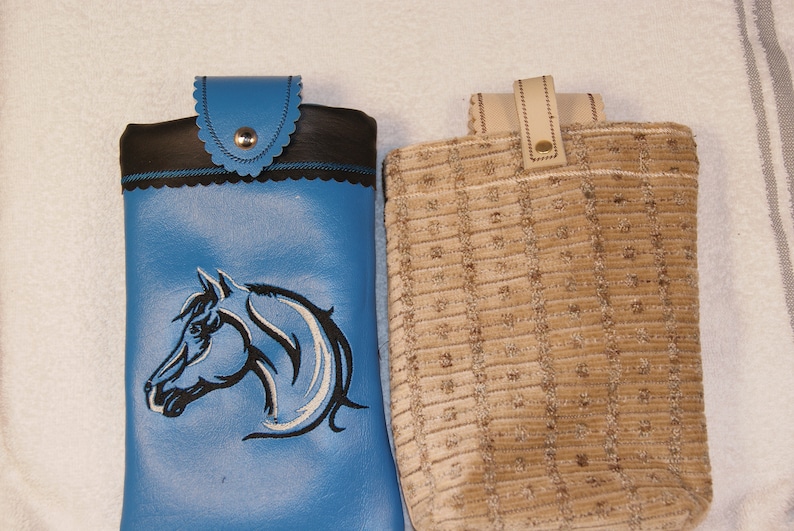 May include: Two small bags, one blue with a black horse design and the other brown with a textured fabric.