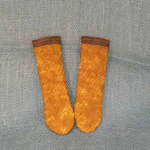 May include: Two brown leather pot holders with a woven pattern. The pot holders have a brown leather trim.