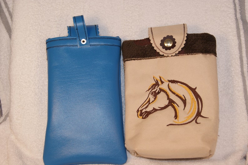 May include: Two phone pouches, one blue and one beige with a brown horse head embroidery.