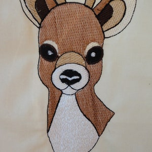 May include: Embroidered design of a brown deer head with white accents. The deer has large, dark eyes and a small, black nose.