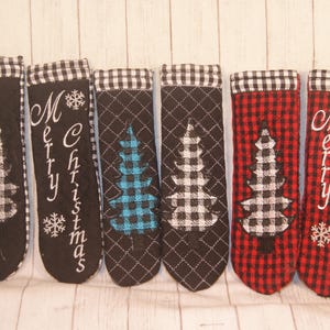 May include: Six black and white plaid Christmas stocking holders with a white tree design and the text "Merry Christmas".