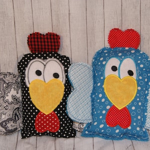 May include: Two handmade plush toy chickens. One is black with white polka dots and a red and black checkered crest. The other is blue with white polka dots and a red crest. Both have yellow beaks and white eyes.