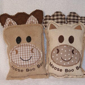 May include: Two plush brown and white stuffed animals shaped like moose with embroidered faces and the text "Moose Boo Boo" on the bottom.