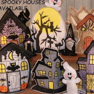 May include: A set of eight spooky Halloween houses, including a tree house, a white house with a crescent moon, a black house with a spider web, a gray house with a ghost, and a purple house with a spider web. The houses are all embroidered with details like windows, doors, and bats.