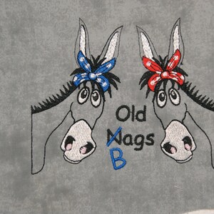May include: Embroidered design of two donkey heads with blue and red bows, the text "Old Nags B" is below the donkeys.