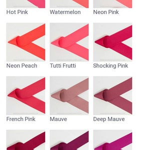 May include: A collection of 12 different pink and red ribbon colors, each displayed in a folded V shape. The colors are: Shell Pink, Pixie Pink, Bubblegum Pink, Hot Pink, Watermelon, Neon Pink, Neon Peach, Tutti Frutti, Shocking Pink, French Pink, Mauve, Deep Mauve, Azalea, Festive Fuchsia, Wild Berry, Raspberry Rose, Red, and Tomato.