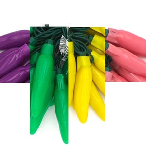 May include: A string of chili pepper shaped Christmas lights with green, yellow, and purple bulbs.